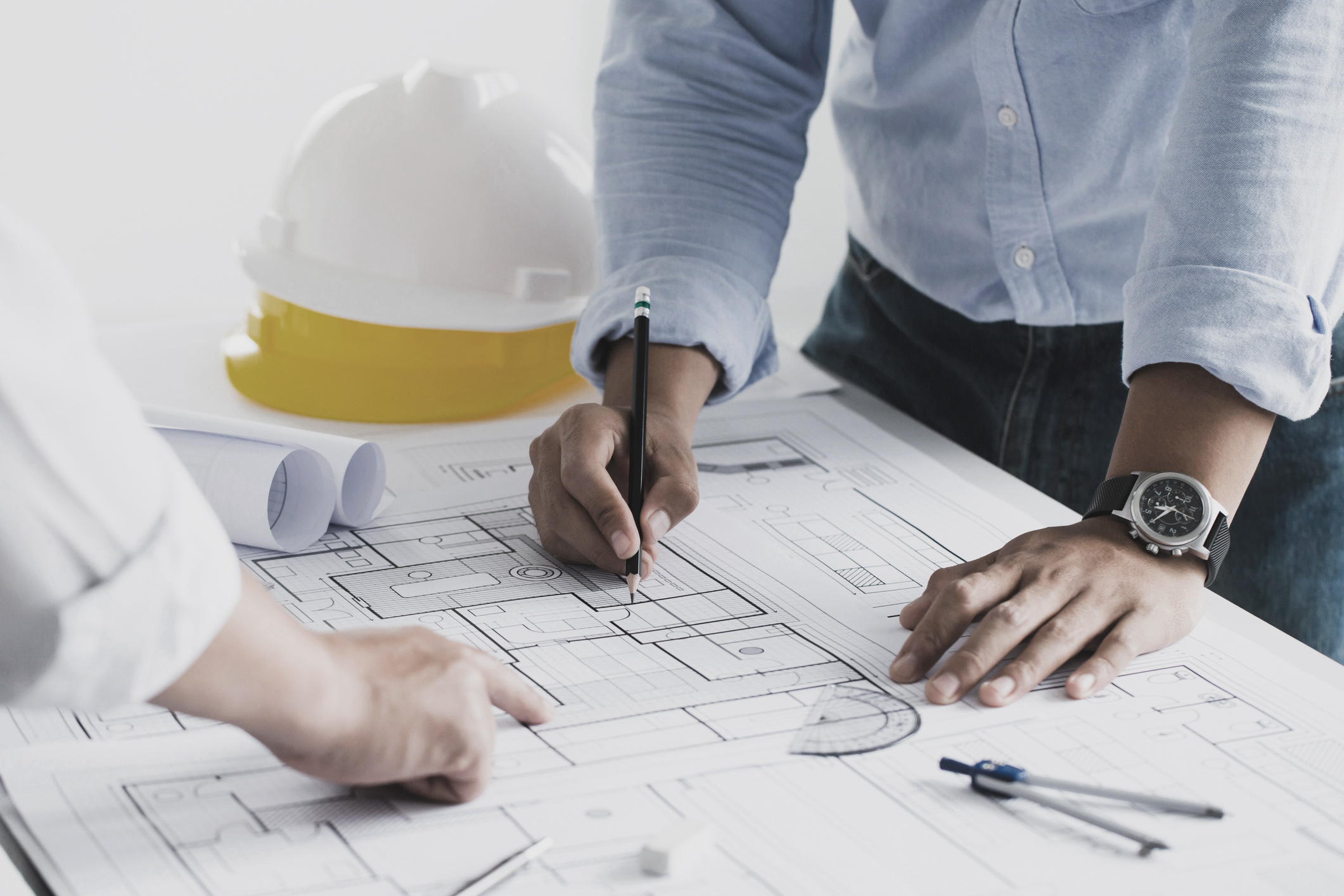 engineer-meeting-for-an-architectural-project-working-with-partner-and-engineering-tools-working-on-blueprint-architectural-project-at-the-construction-site-at-desk-in-the-office
