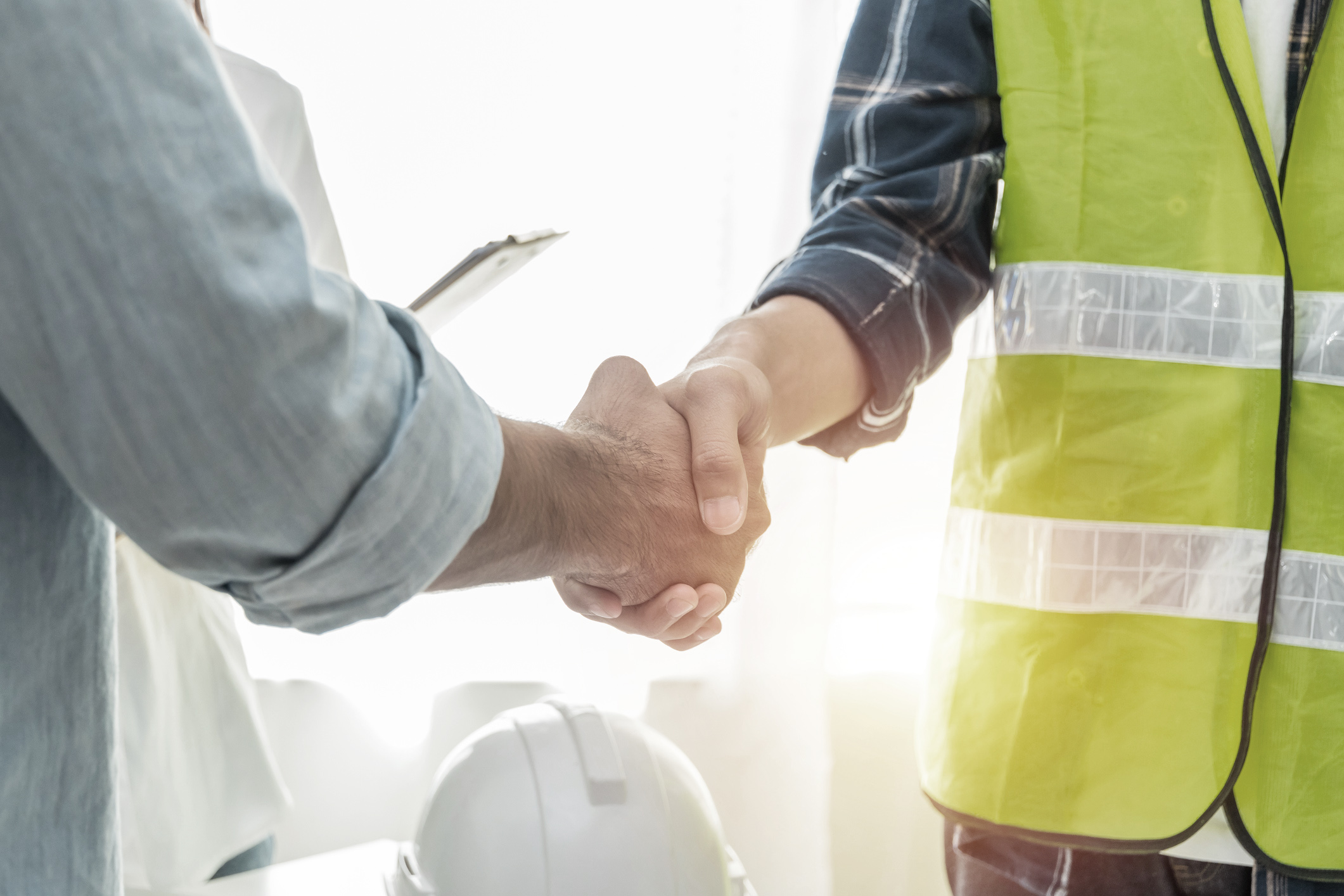 contractor-construction-worker-team-hands-shaking-after-plan-project-contract-on-workplace-desk-in-meeting-room-office-at-construction-site-contractor-engineering-partnership-construction-concept
